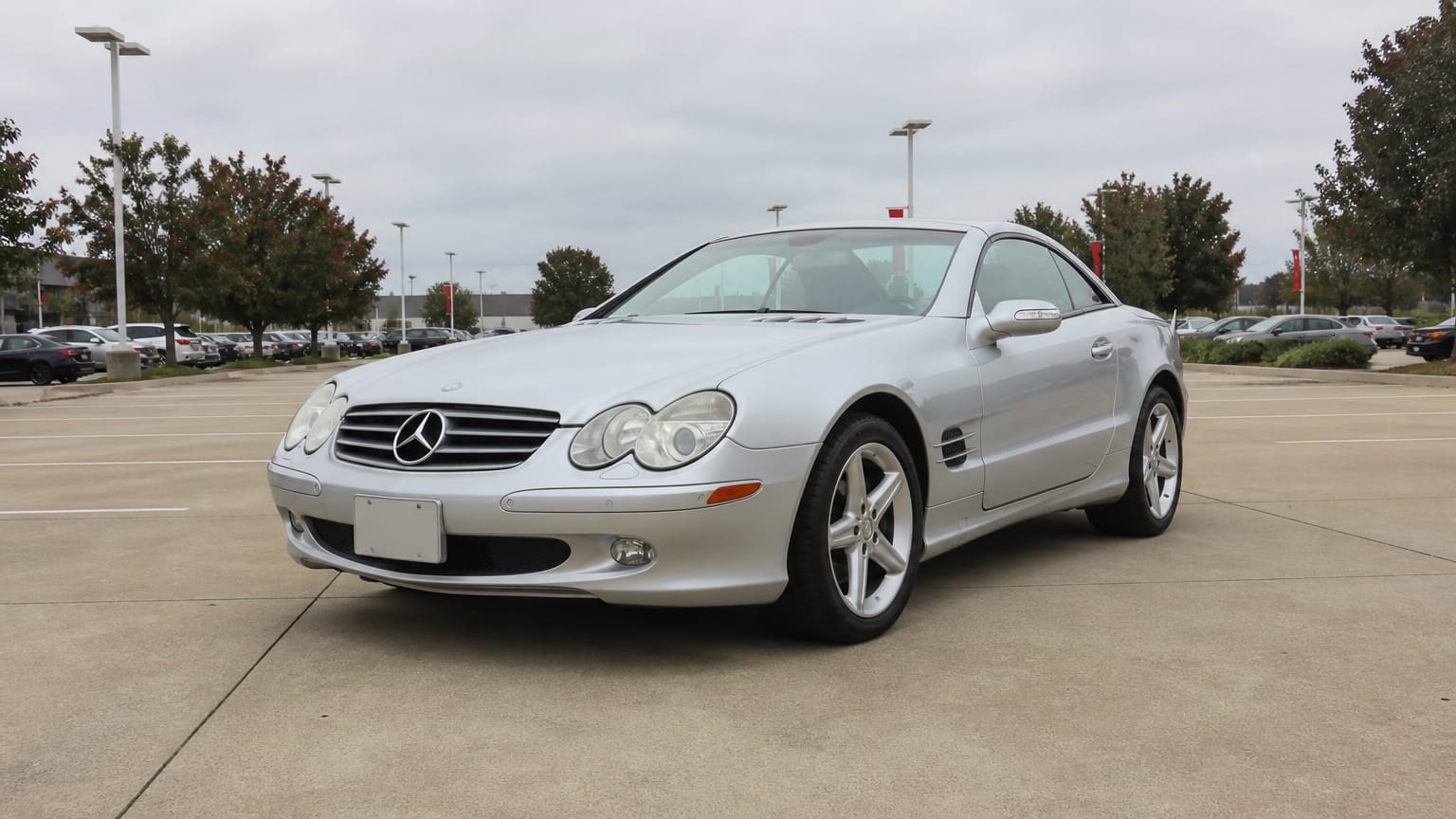 A higher-risk Mercedes-Benz SL model year parked in a dealership lot.
