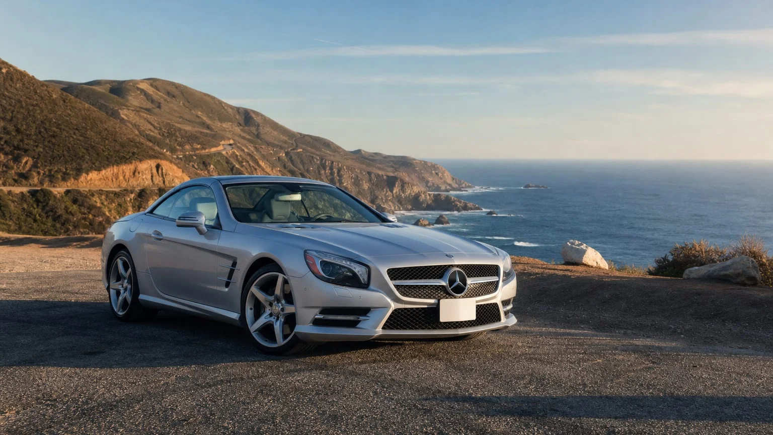 A Mercedes-Benz SL luxury roadster, three-quarter front view, parked on a quiet street.