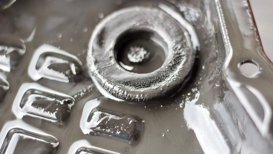 a close up of a metal object with a blurry background.|the back end of a car with a lot of smoke coming out of it.|a close up of a metal object with ice on it.