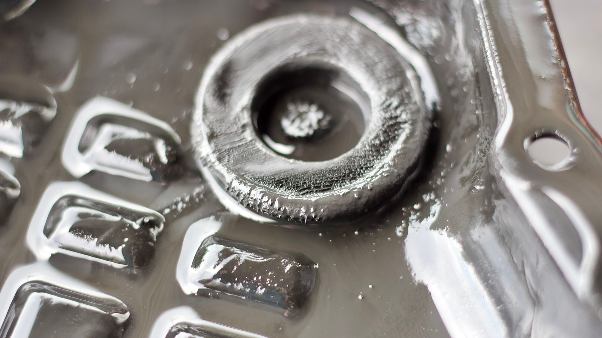 a close up of a metal object with a blurry background.|the back end of a car with a lot of smoke coming out of it.|a close up of a metal object with ice on it.