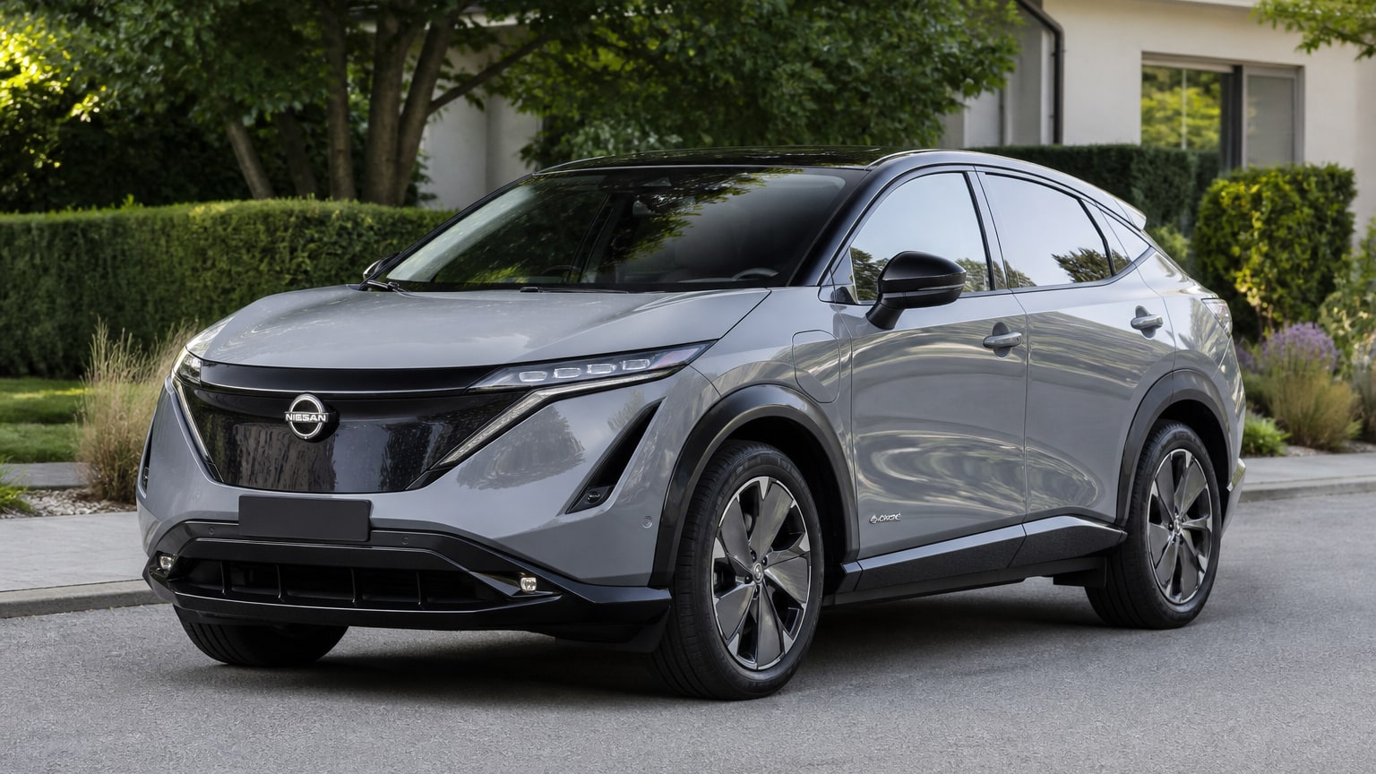 A Nissan Ariya parked outdoors, three-quarter front view.