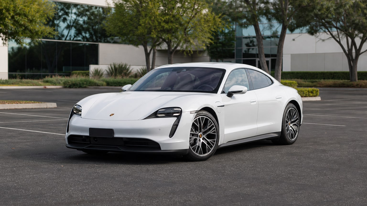 A Porsche Taycan parked outdoors, three-quarter front view.