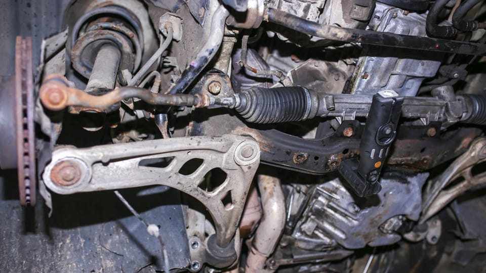 a close up of a metal object with a wrench.|a machine that is sitting on a table.|a person pouring a liquid into a car engine.