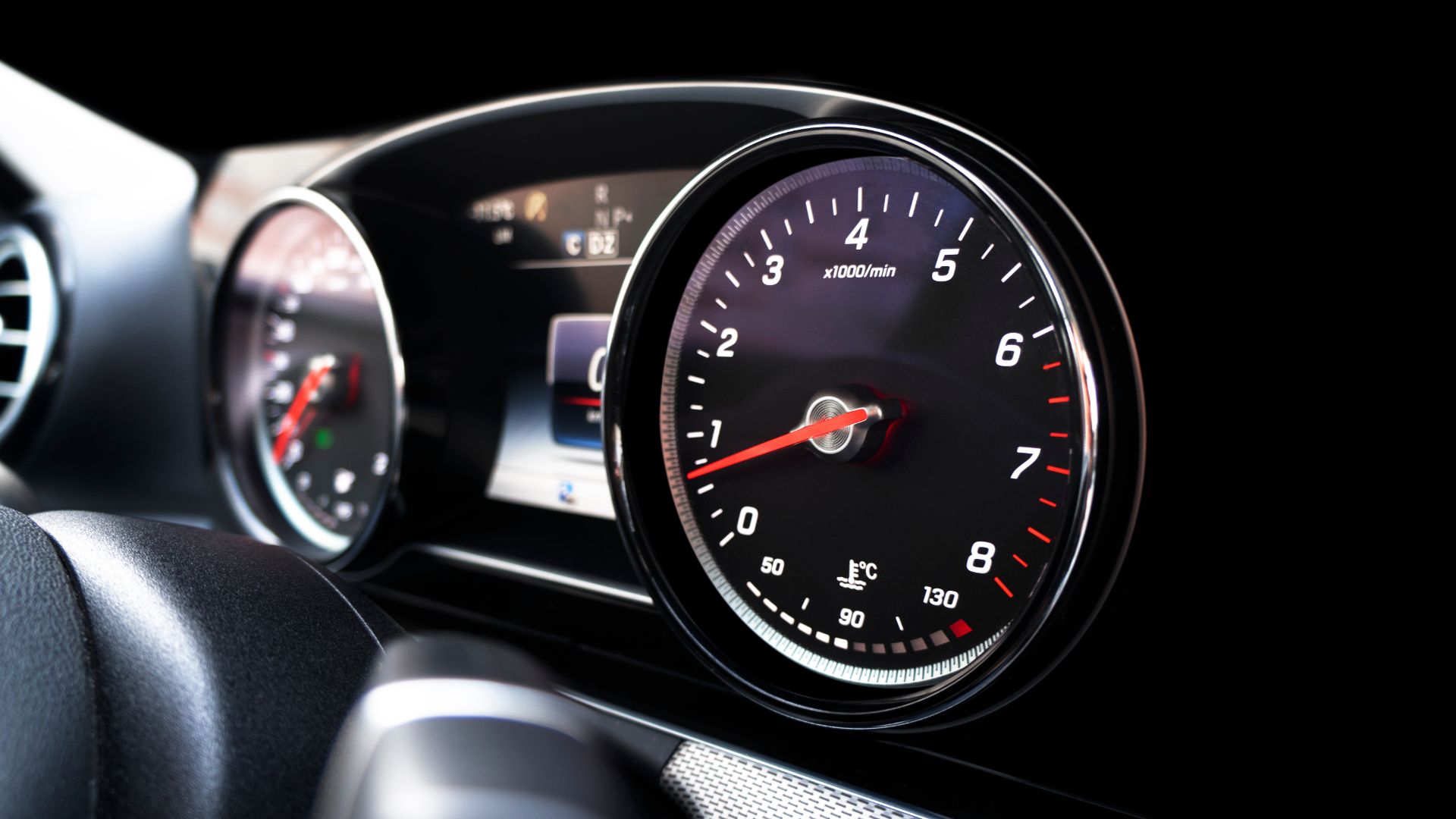 a close up of a speedometer on a car.|a man is working on a car engine.