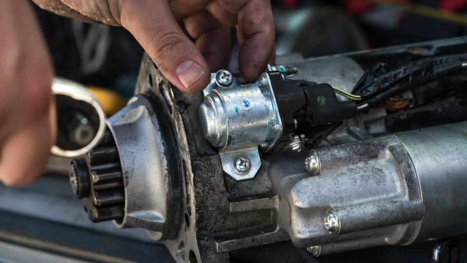 a close up of a person working on a motor.|a pile of metal objects that are stacked on top of each other.