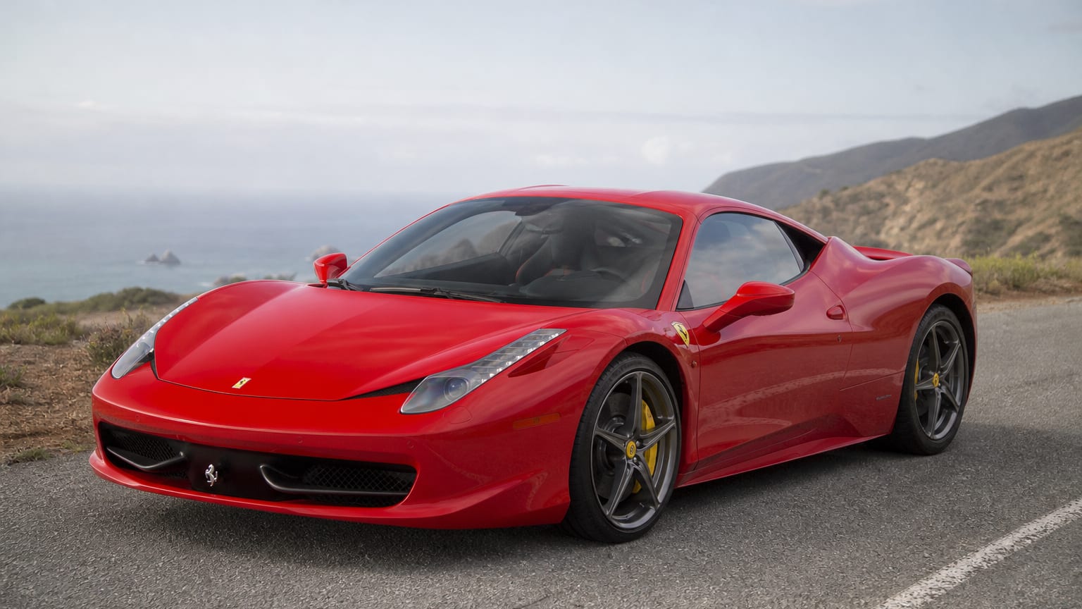 Rosso red Ferrari 458 Italia parked on a coastal road