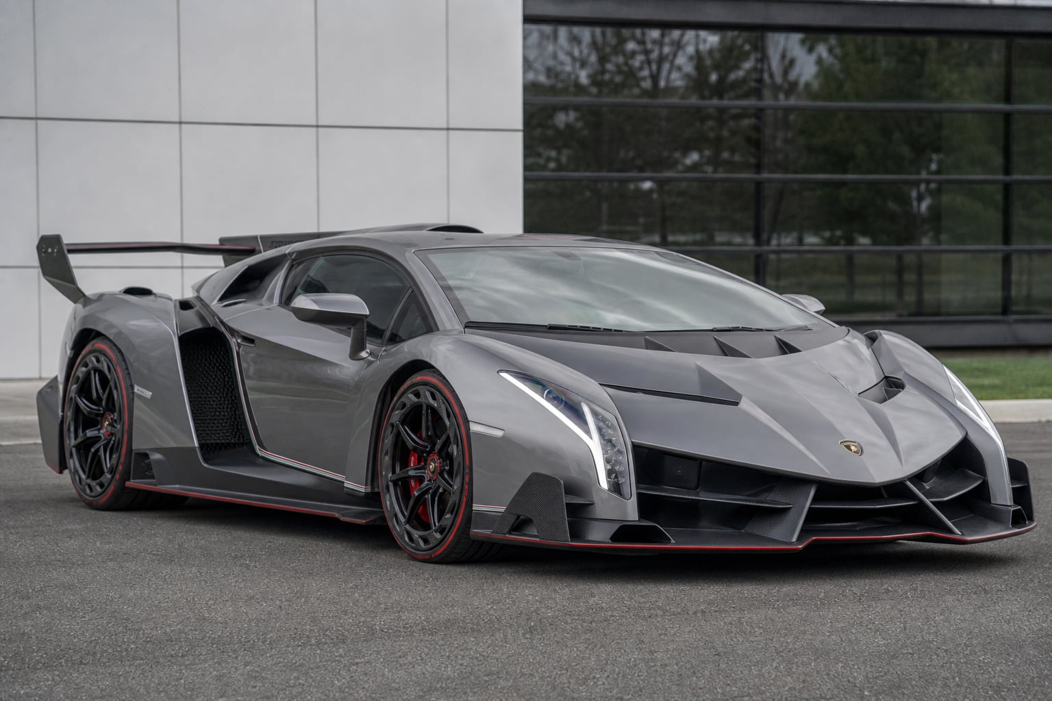 Gray Lamborghini Veneno hypercar parked outside a modern building