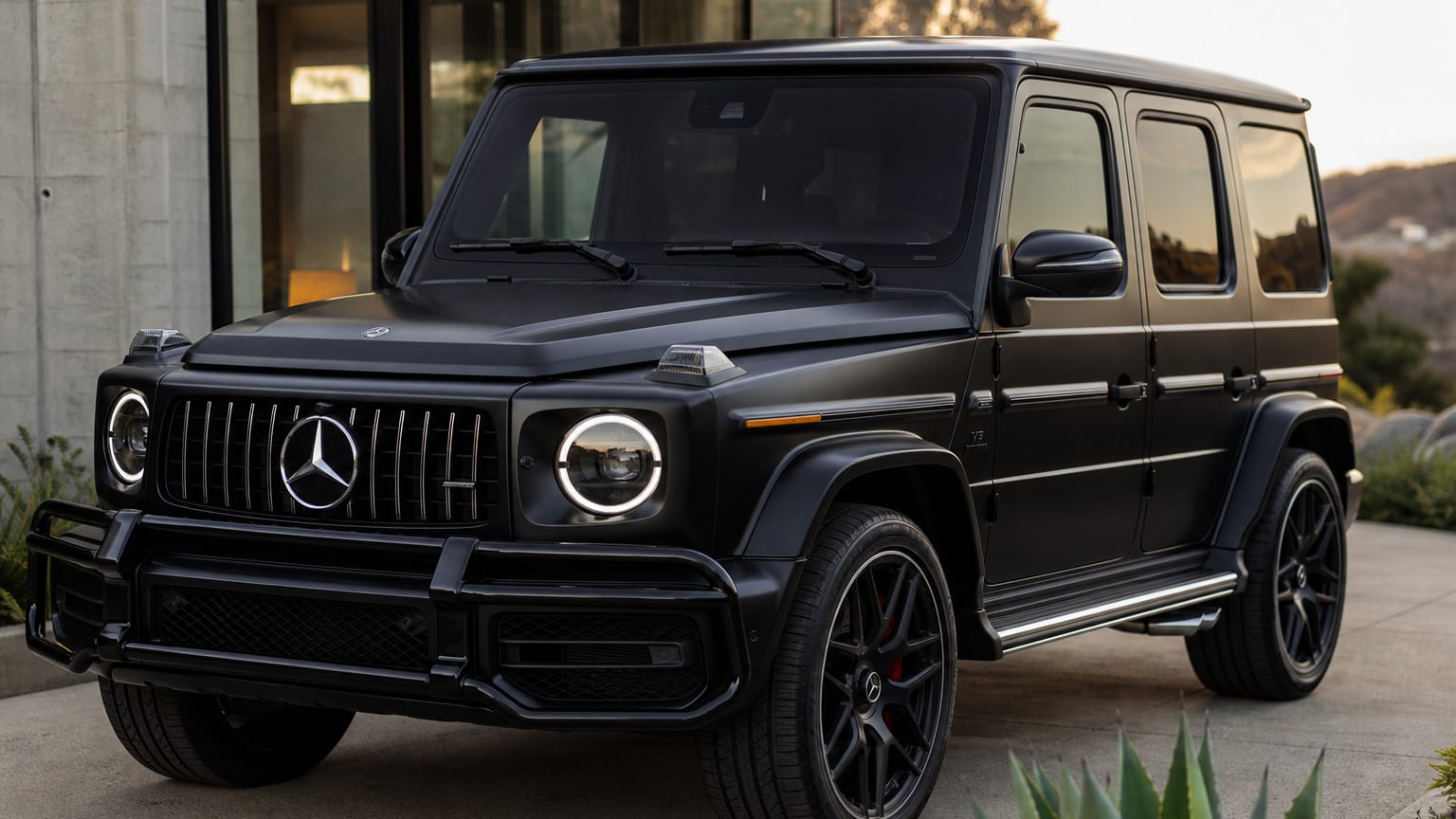 Matte black Mercedes-Benz G63 AMG G-Wagon parked outside a modern home
