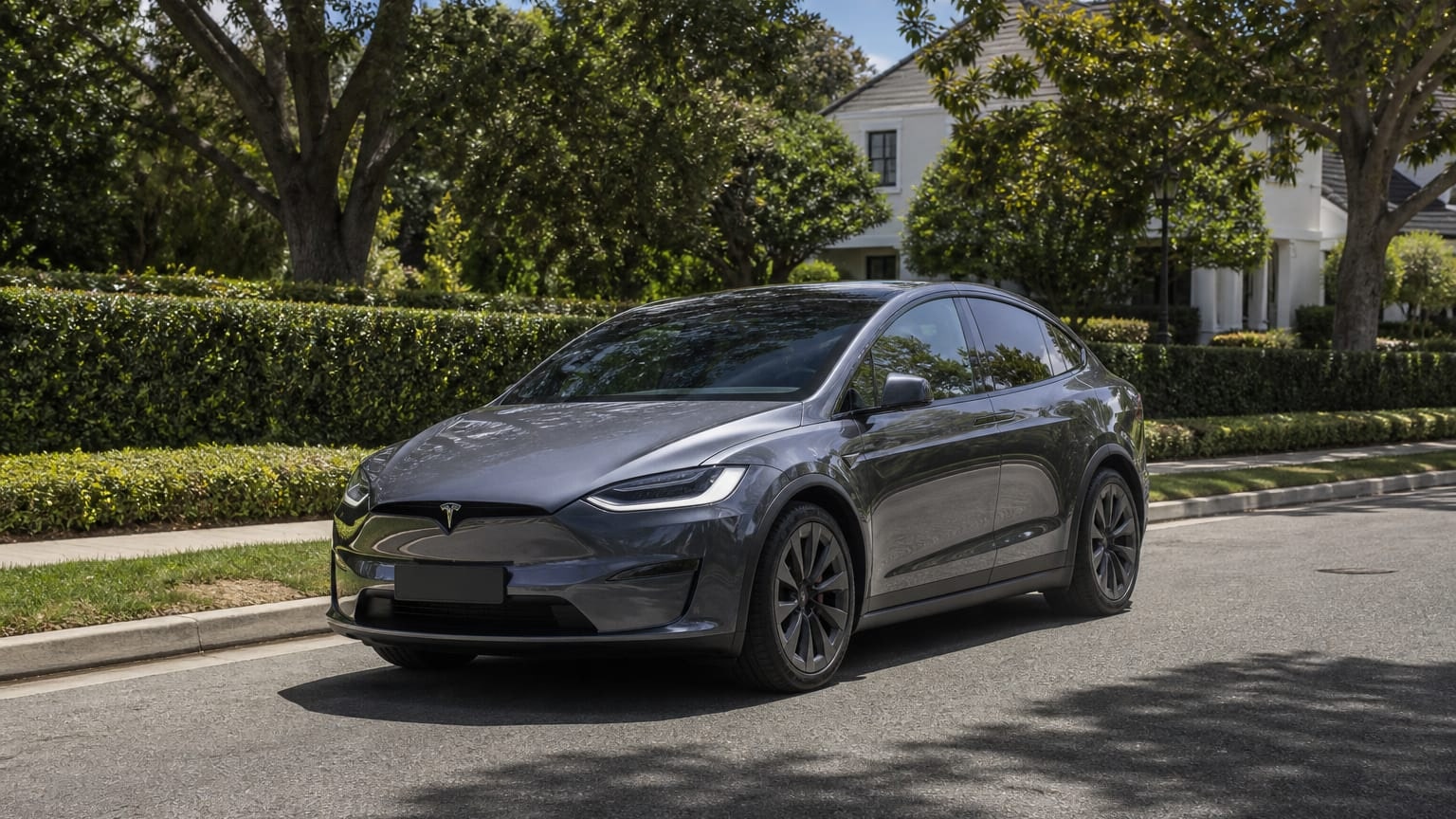 A cleaner later-model Tesla Model X on a quiet road.