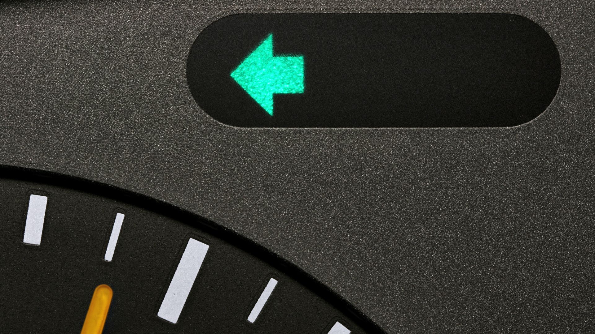 a person holding a remote control in a car.|a close up of a clock with a green arrow on it.|a man is working on a car's engine.|a person holding a small object in their hand.